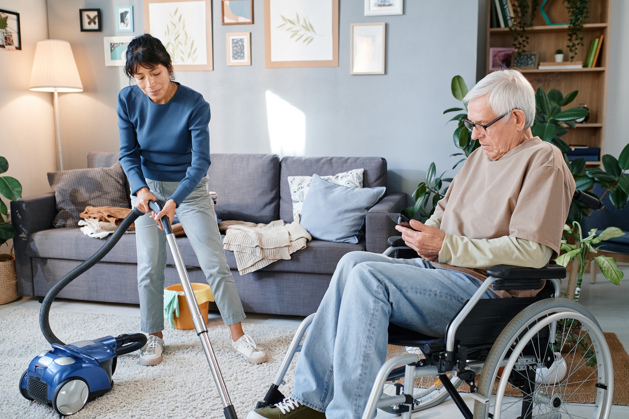 Housekeeper cleaning the room of senior man